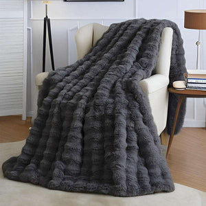 Luxury Tuscany Fleece throw blanket in charcoal grey faux fur with a plush raised bubble texture draped over a chair
