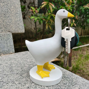 Magnetic Goose Key Holder in white resin with a yellow beak and feet, holding a metal key ring in its beak