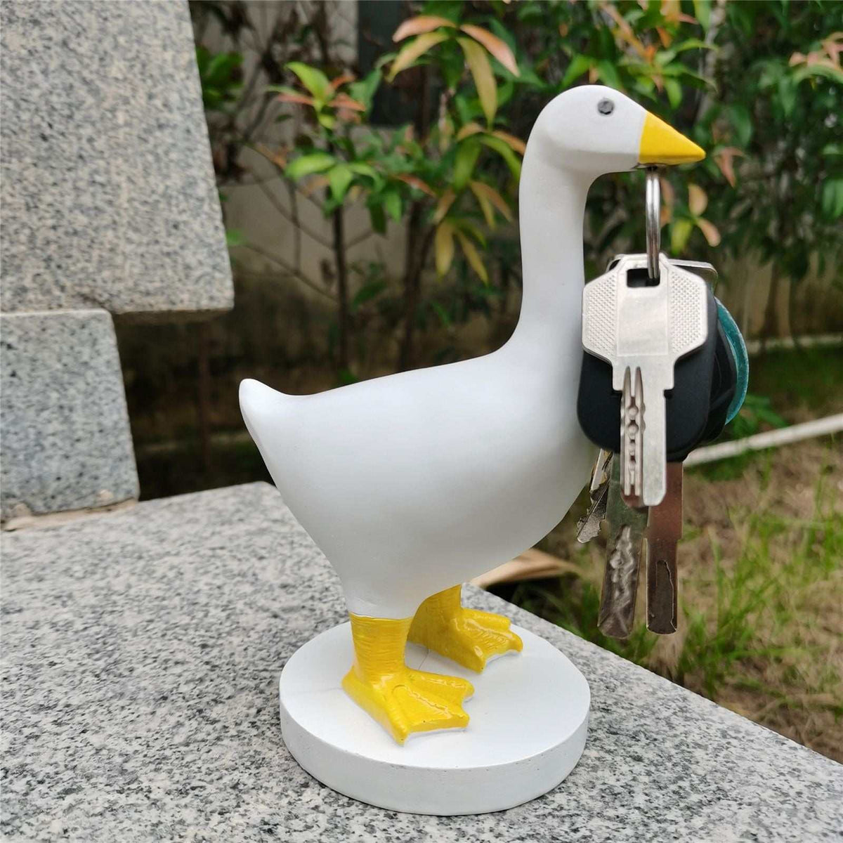 Magnetic Goose Key Holder in white resin with a yellow beak and feet, holding a metal key ring in its beak