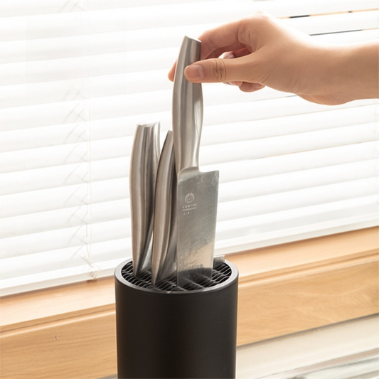 Matte Black Modern cylindrical knife block in PP with a wavy universal insert holding several stainless steel knives