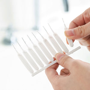 Mini Shower Head Cleaning Brush set with white ribbed plastic handles and fine metal cleaning tips, held in hands