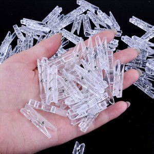 Mini Transparent Plastic clips shown as small clear plastic spring clips with visible metal pivots, piled in a hand