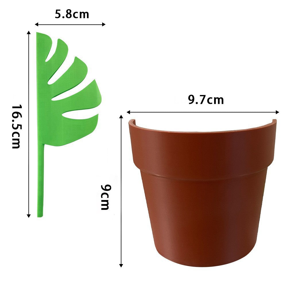 Planter organiser with green plastic Monstera half-leaf divider and brown ABS base, featuring a tropical split-leaf shape