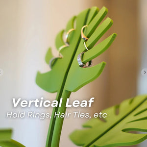 Mirror-Mount Half-Leaf Monstera organiser in bright green plastic, with leaf-shaped slots holding rings and hair ties