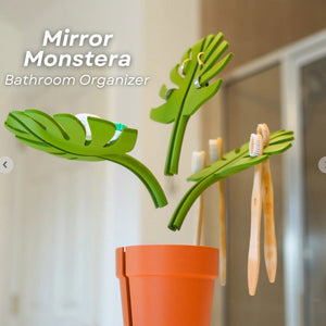 Mirror-Mount Half-Leaf Monstera organizer in bright green plastic with three leaf-shaped dividers and an orange planter base