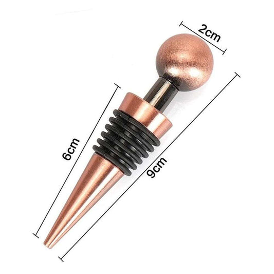 Wine bottle stopper in rose gold stainless steel with a metallic ball top and black ribbed silicone sealing rings.