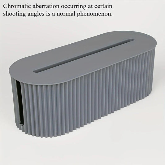 Multi-Scene Cable Storage Box in muted gray plastic with a ribbed oval body, fitted lid and long cable slot