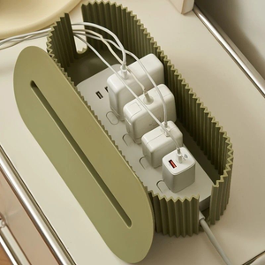 Multi-Scene Cable Storage Box in olive green plastic with a ribbed body and oval lid, holding white chargers and cables