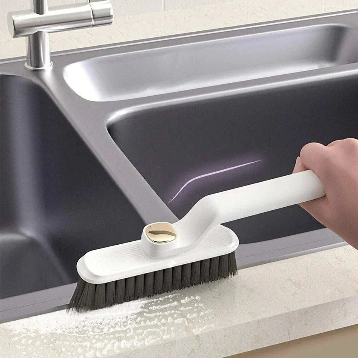 Multifunctional 360° Rotary Cleaning Brush with a white plastic handle and dense dark bristles scrubbing a sink edge