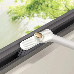 Multifunctional 360° Rotary Cleaning Brush with a white plastic handle, ridged head and dark bristles cleaning a window track