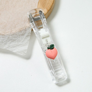Office Supplies Push Stapler with a clear plastic body and pink peach charm with a green leaf detail