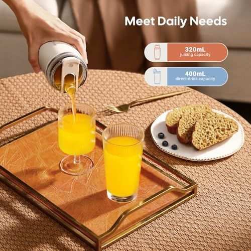 Personal Juicer with a white cylindrical cup and metallic blade base, pouring bright orange juice into a glass