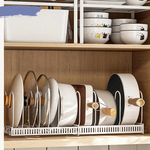Pot Lid Rack Iron in a white wire frame holds pot lids upright with adjustable slots inside a wooden cabinet.