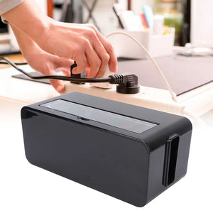 Power Socket Storage Box in black plastic with a long translucent top lid and side cable slot, shown storing a power strip