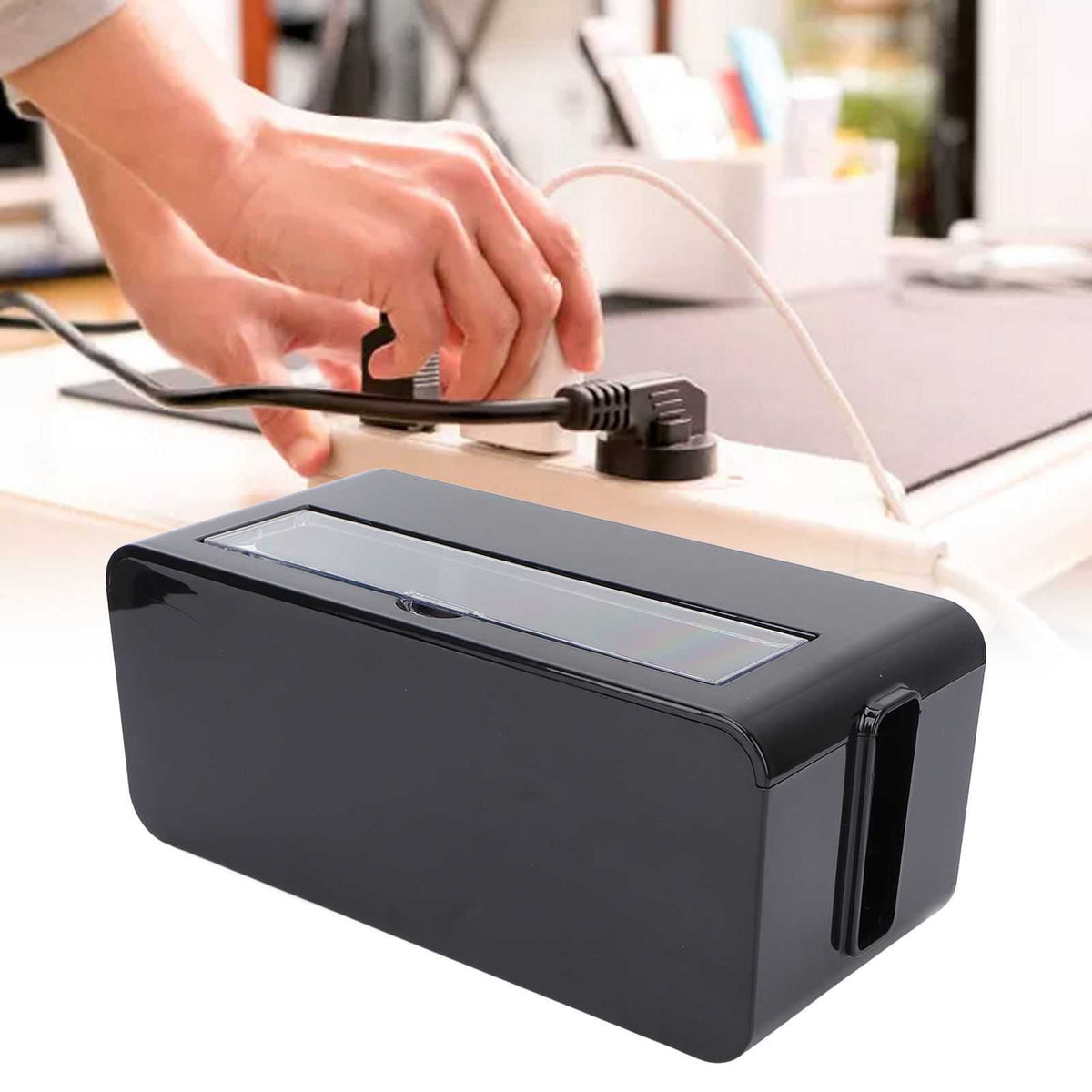Power Socket Storage Box in black plastic with a long translucent top lid and side cable slot, shown storing a power strip