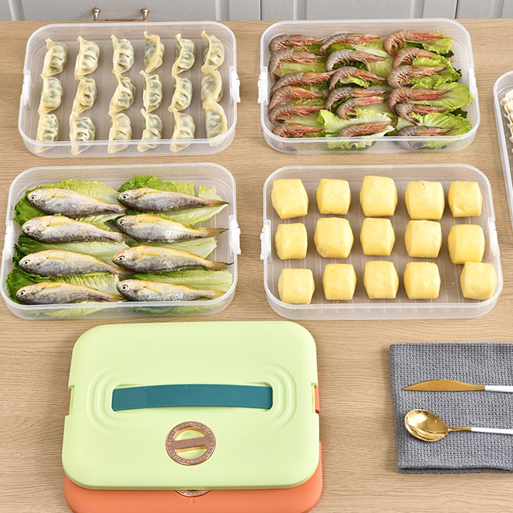 Stackable food storage trays with clear plastic bases and green and orange lids, holding dumplings, shrimp, fish and tofu on a Refrigerator Food Shelf