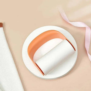 Reusable Lint Roller with orange plastic handle and white adhesive refill roll for removing pet hair and lint