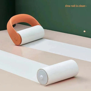 Reusable Lint Roller with orange plastic handle and white refill roll, showing one used and one clean roll on a neutral surface