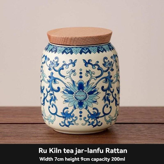 Ru Kiln tea jar in pale blue and white ceramic with ornate floral patterns and a flat tan rattan lid