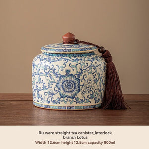 Ru Kiln tea jar in cream ceramic with blue floral and scrollwork pattern, matching lid and tassel