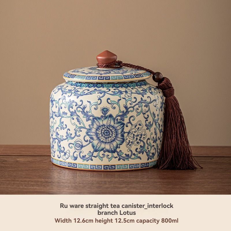 Ru Kiln tea jar in cream ceramic with blue floral and scrollwork pattern, matching lid and tassel