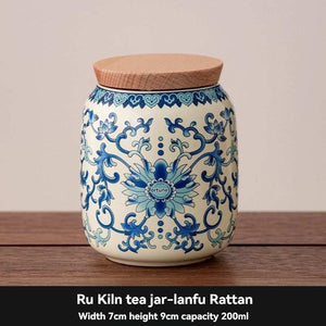 Ru Kiln tea jar in cream ceramic with intricate blue floral scrollwork and a flat tan wood-grain lid