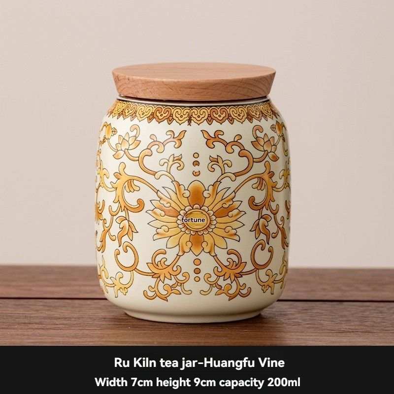 Ru Kiln tea jar in cream ceramic with ornate orange-gold floral scrollwork and a flat wooden lid