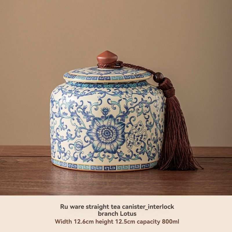 Ru Kiln tea jar in cyan ceramic with blue floral scrollwork, a matching lid, and a decorative tassel