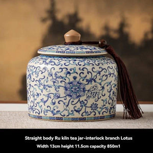 Ru Kiln tea jar in white ceramic with intricate blue floral patterns, a fitted lid, and decorative tassel