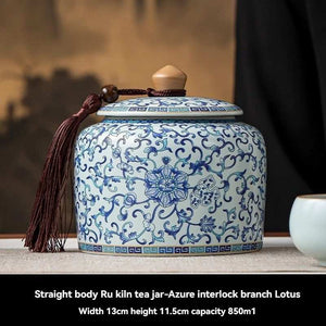 Ru Kiln tea jar in white ceramic with intricate blue floral and interlocking border patterns, domed lid and tassel
