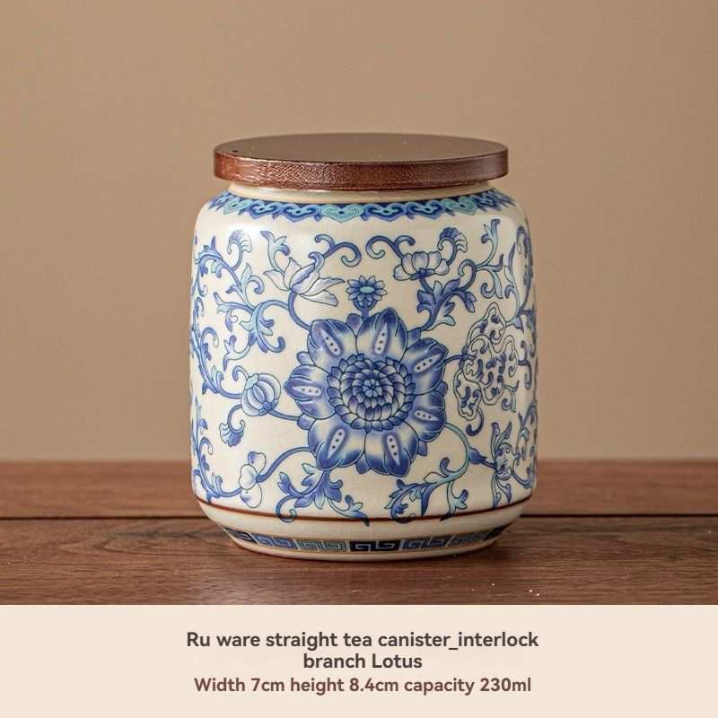 Ru Kiln tea jar in glossy white ceramic with ornate blue floral and scroll pattern and a flat brown lid