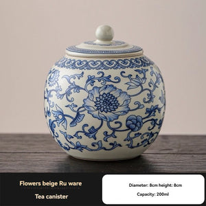 Ru Kiln tea jar, round white ceramic canister with intricate blue floral scrollwork and a matching knobbed lid.