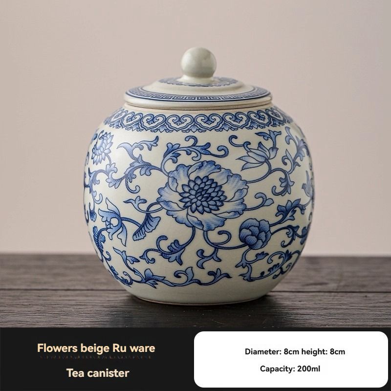 Ru Kiln tea jar, round white ceramic canister with intricate blue floral scrollwork and a matching knobbed lid.