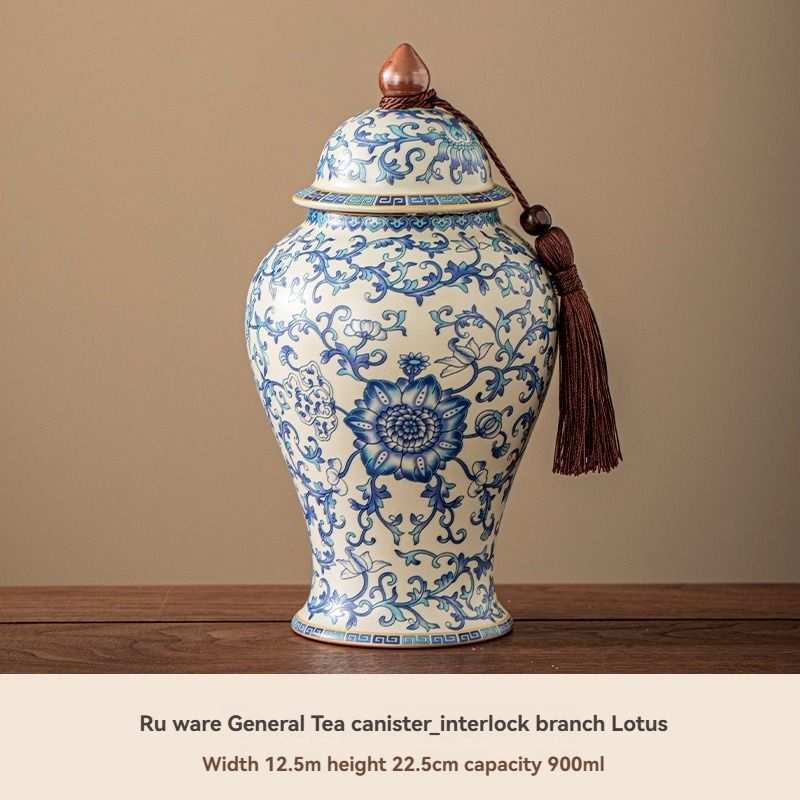 Ru Kiln tea jar in white ceramic with intricate blue floral and lotus pattern, domed lid and hanging tassel