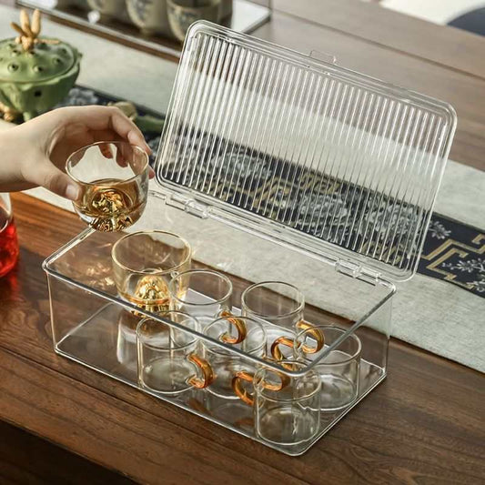 Stackable Organizer Bin Hinged Lid in clear plastic, with an open ribbed lid and small glass cups stored inside