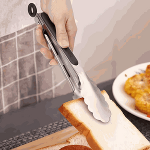 Stainless steel kitchen tongs set with black silicone grips and scalloped metal tips holding a slice of toast