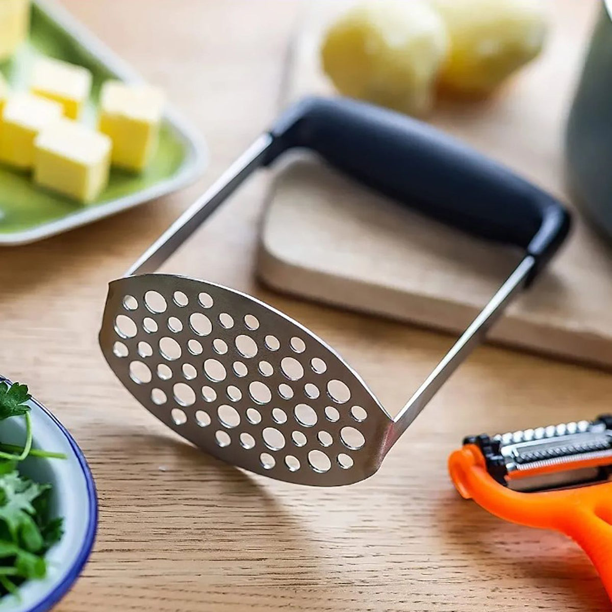 Stainless Steel Potato Masher with a perforated steel mashing plate and wide black horizontal grip