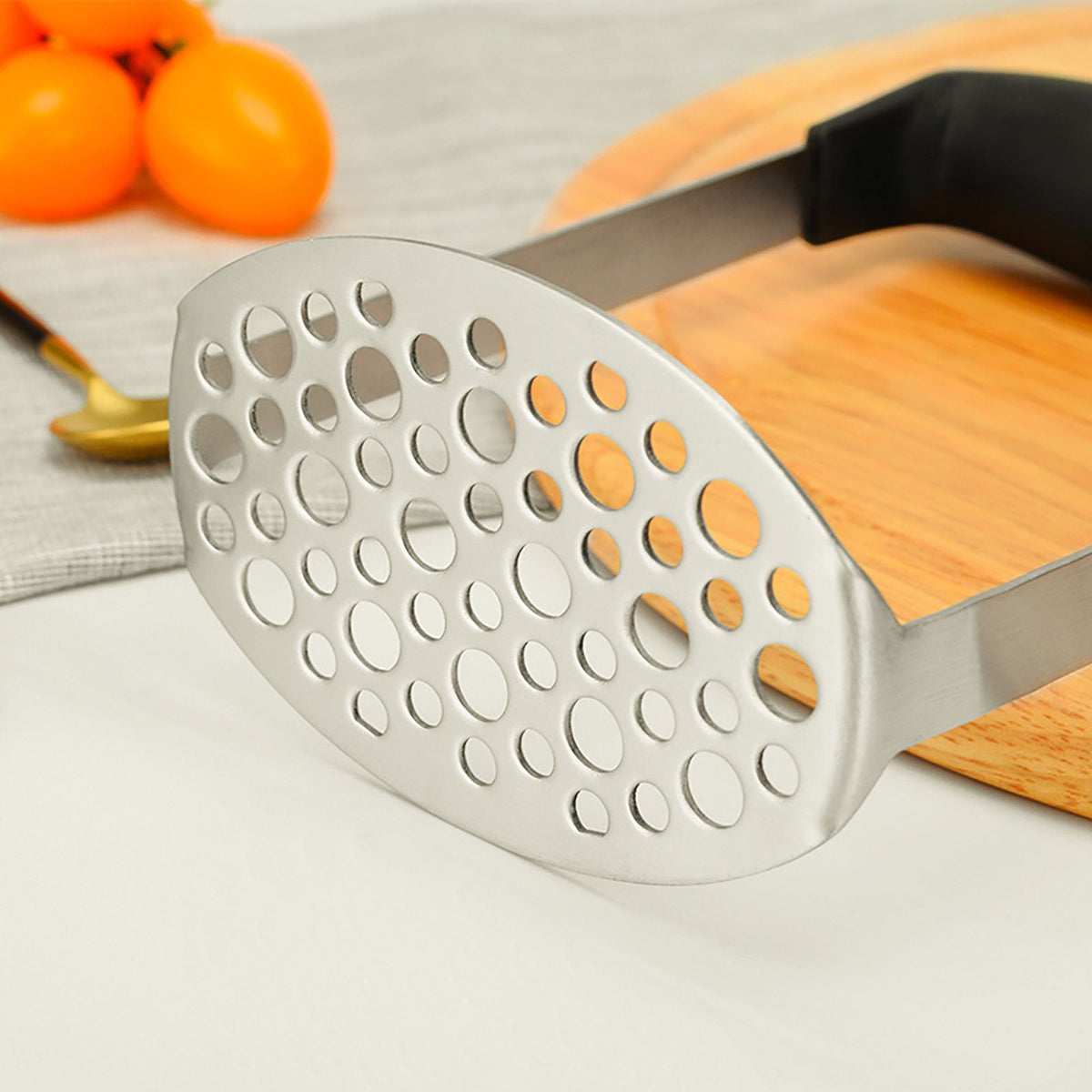 Stainless Steel Potato Masher with a silver perforated oval mashing plate and wide black horizontal grip