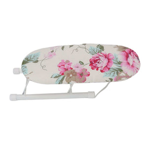 Tabletop Ironing Board with an ivory fabric cover, pink peony flowers and green leaves on a folding white metal frame