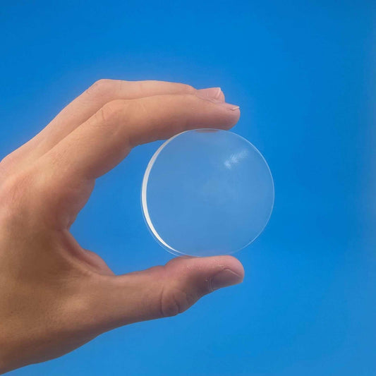 Wall Protector shown as a clear, round, smooth silicone pad held between fingers, with a thin raised rim