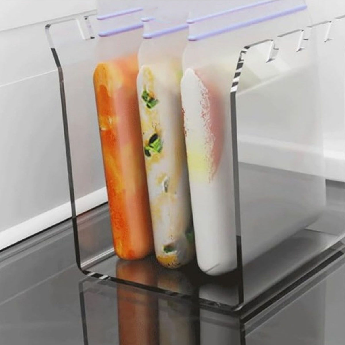 Ziplock Bag Holder made of clear acrylic, with three upright filled bags held open by lavender clips